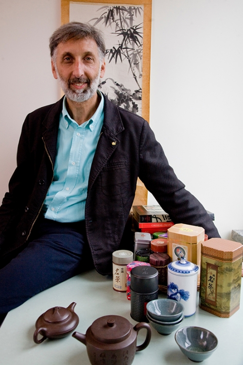 Alan Berkowitz stands in his office surrounded by Asian tea accoutrements. 