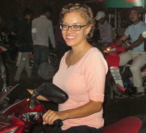 woman in glasses sitting on a motorbike