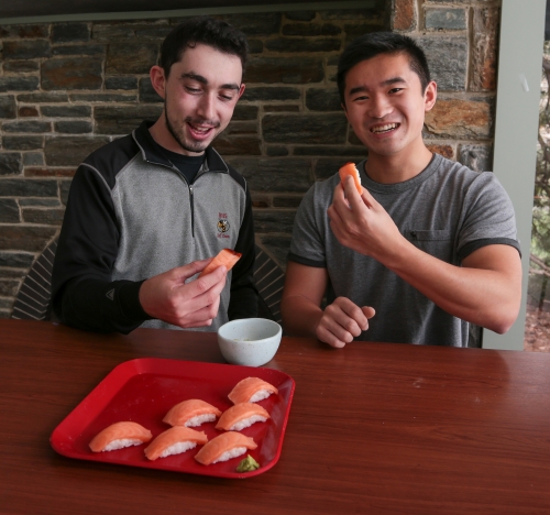two young men eating sushi
