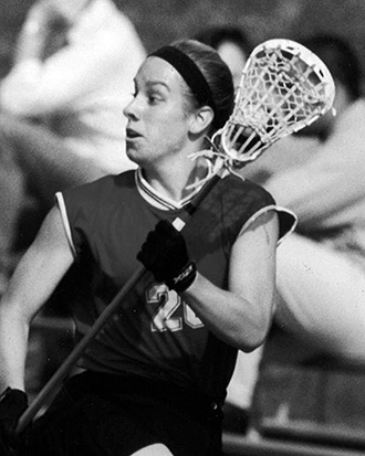 Kristen English ’01, holds a lacrosse stick an is a standout for the Garnet in field hockey, basketball, and lacrosse and one of the only Swarthmore athletes to earn All-America status in multiple sports. 