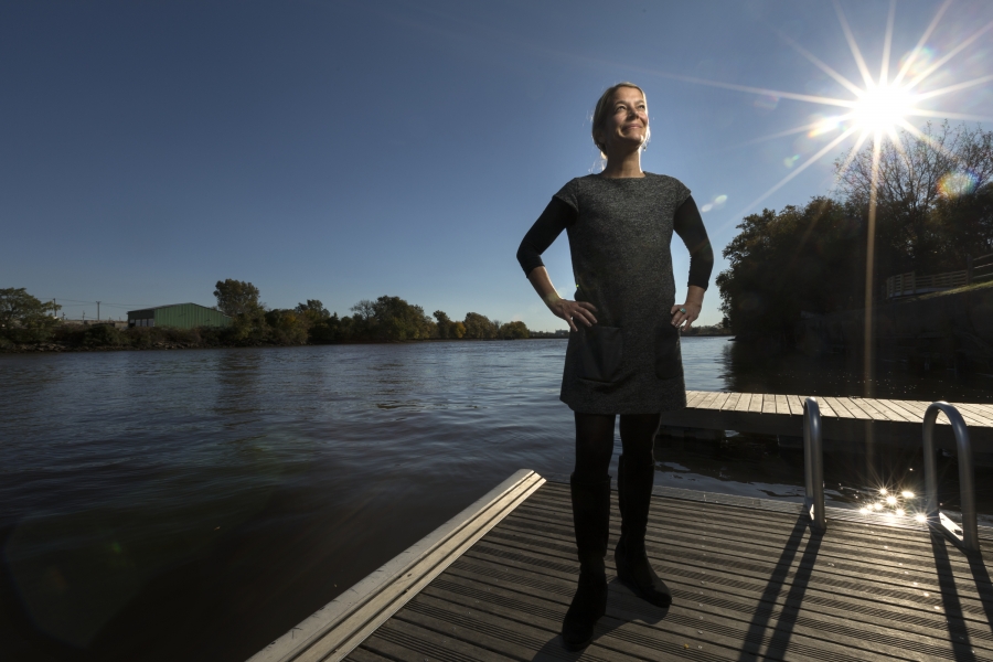 woman stands on dock near river 