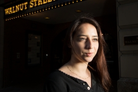 student/professional actress poses in front of a theater