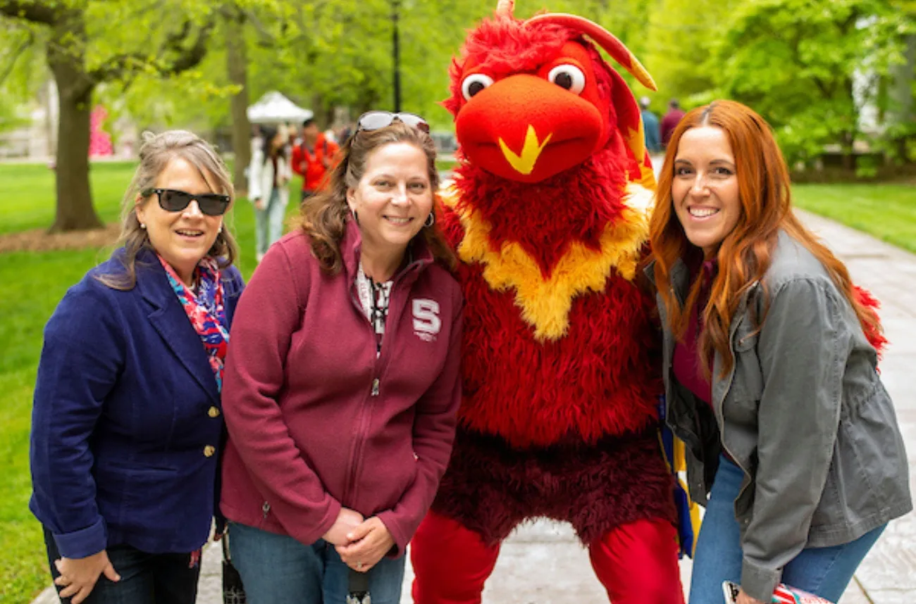 Phineas the phoenix poses with staff members