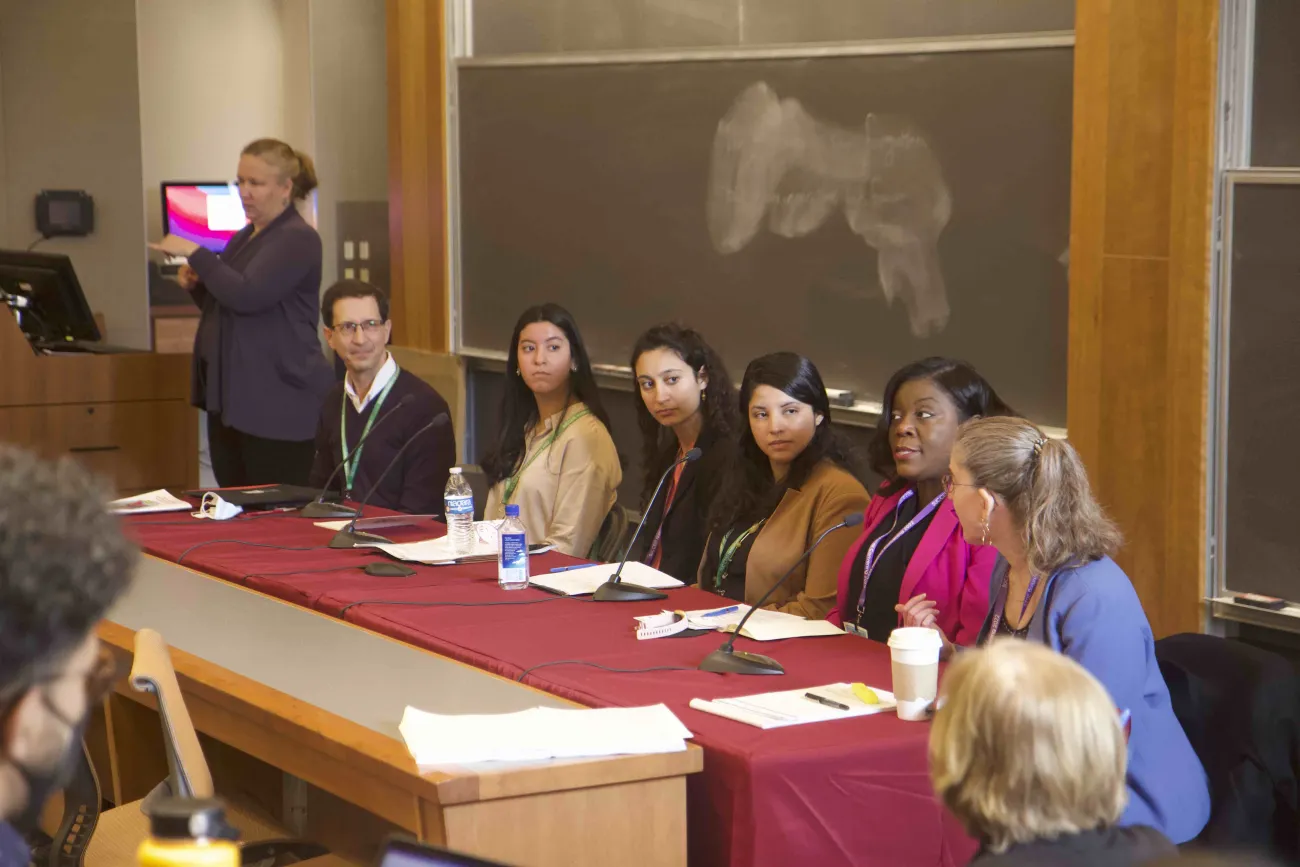 panel of speakers listens while one speaks