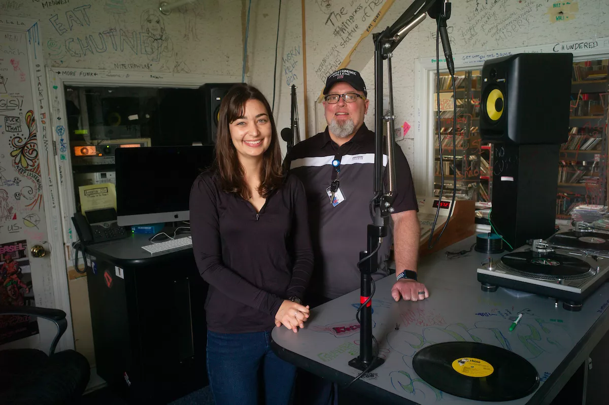 Student and staff member pose in radio station