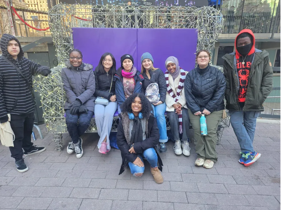 Students seated in front of a purple background