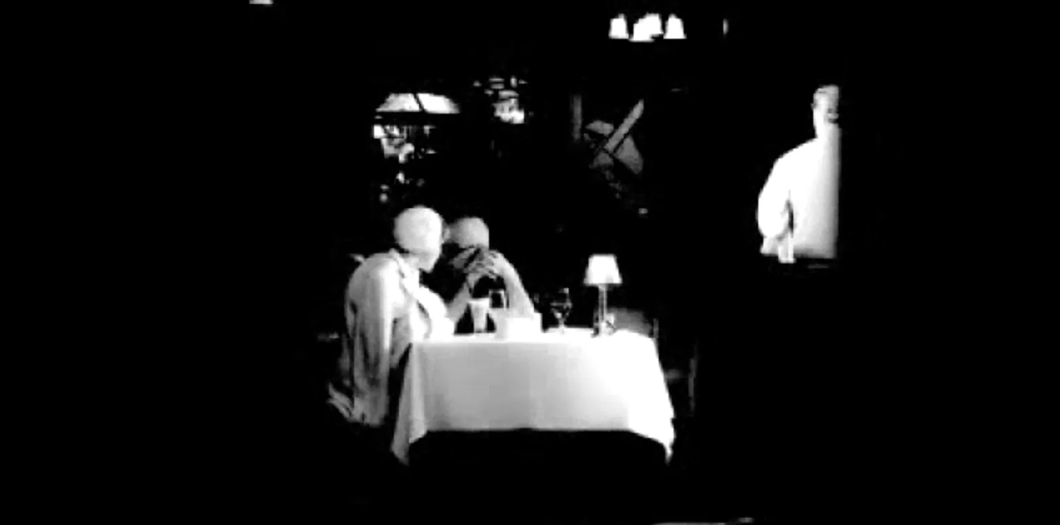 black and white photo of 2 people at restaurant table