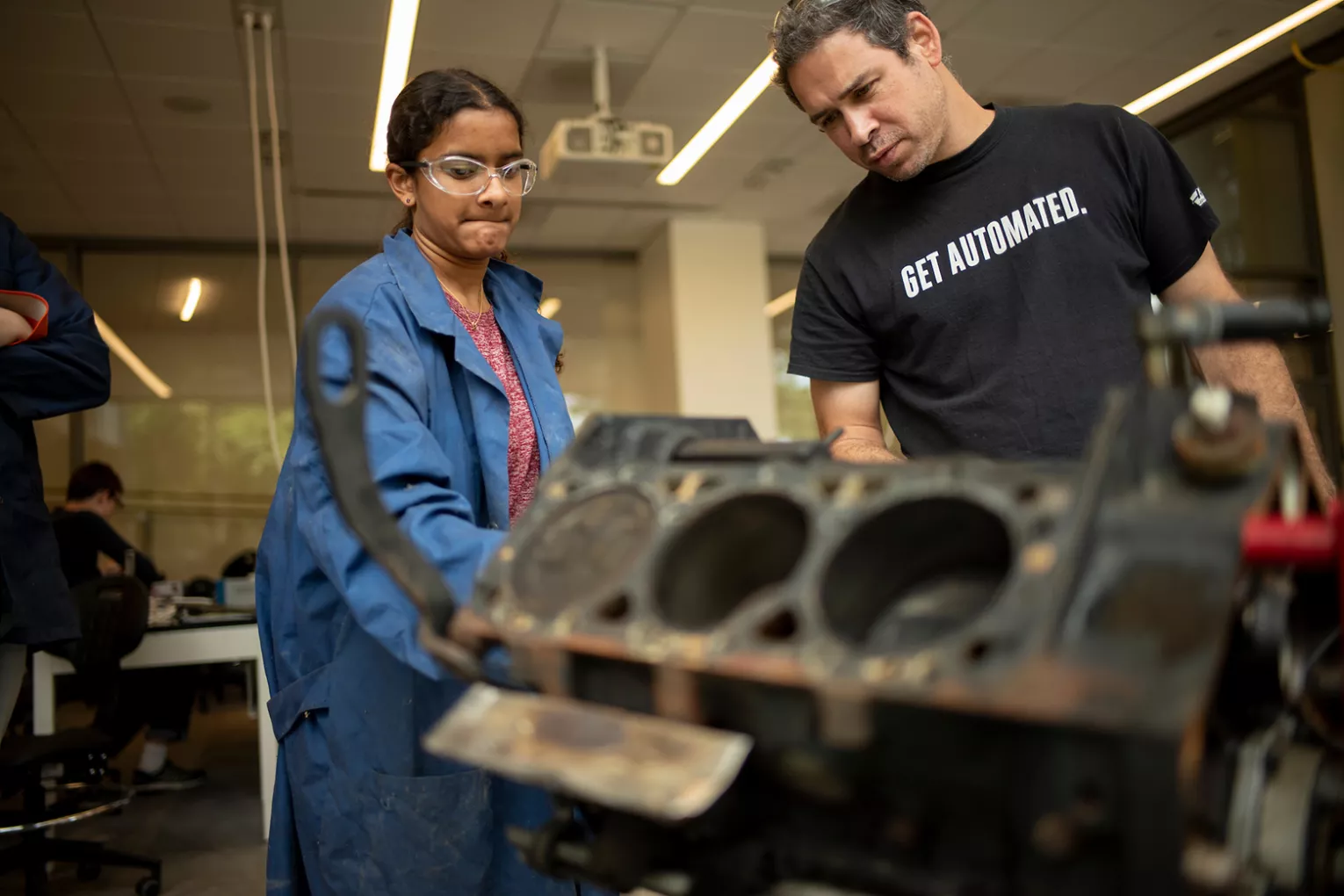 Student works on engine block in lab