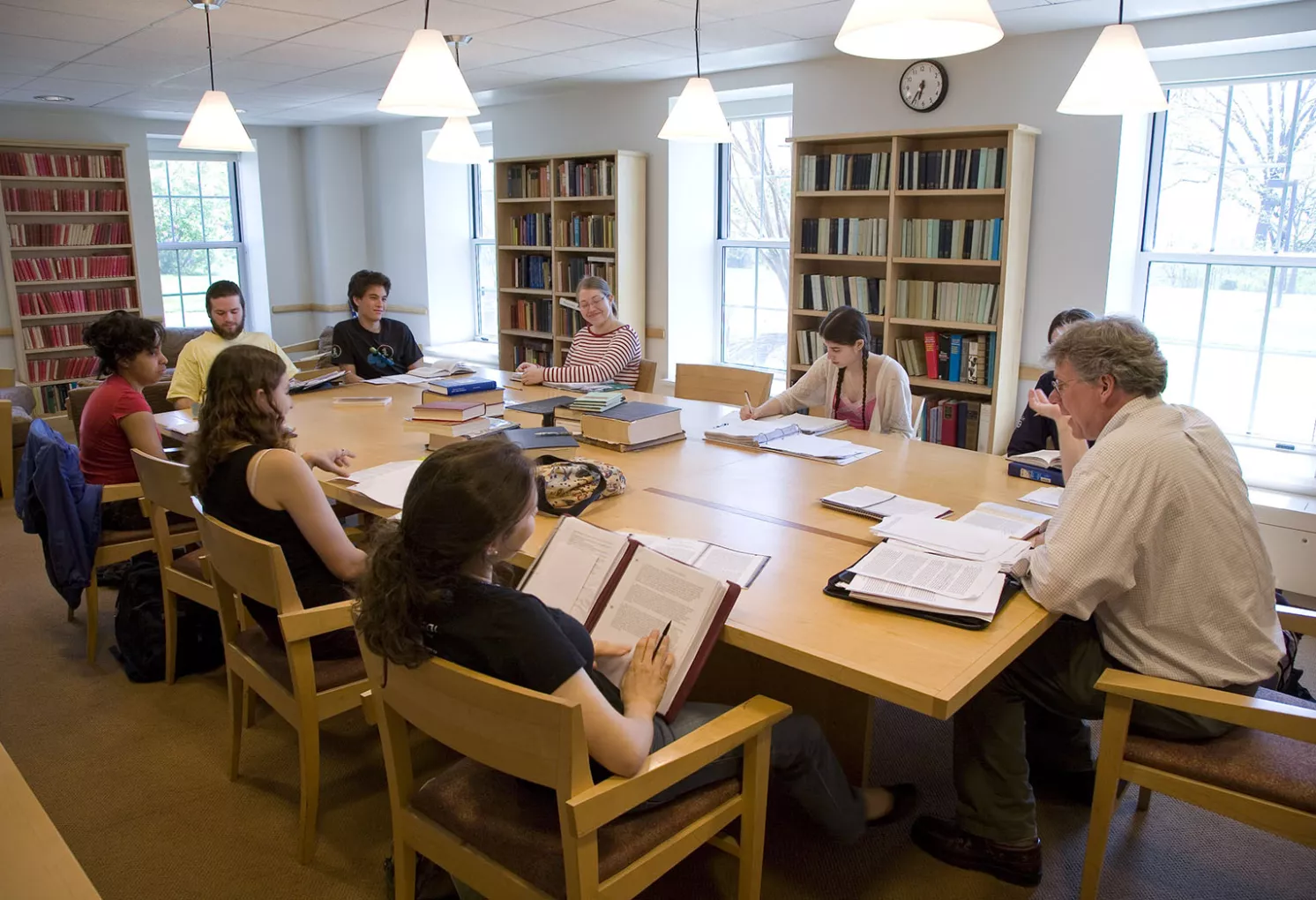 Professor leading a classroom discussion around a table