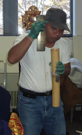 Pak Kartawan compares the pitch of a bronze key and its resonator.