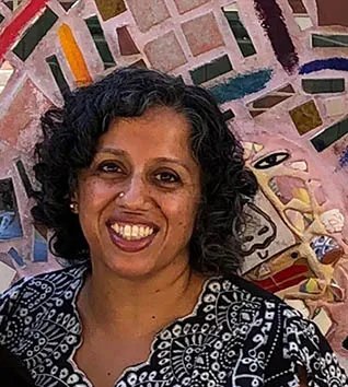 Bakirathi Mani in front of a colorful mosaic