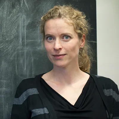 Eva-Maria Collins in front of a blackboard