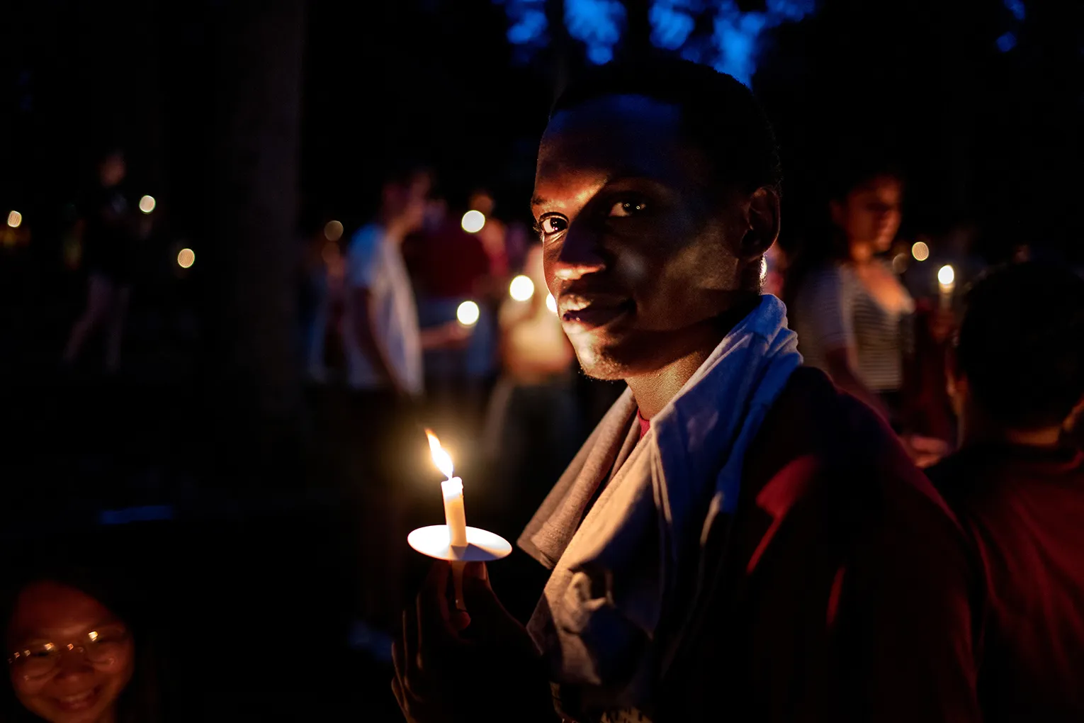 Student holds candle at night