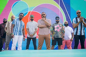 Dupont Brass Band members pose in front of colorful outdoor mural