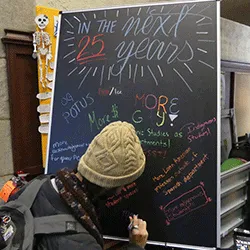 A student writes on a chalkboard