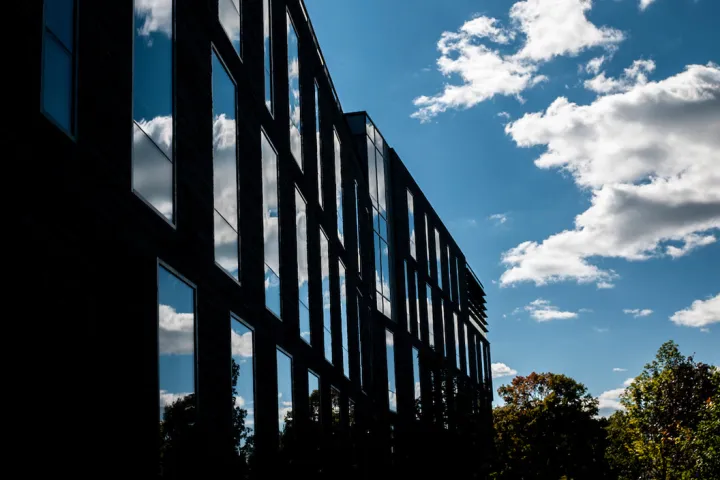 Singer Hall reflecting clouds and blue sky