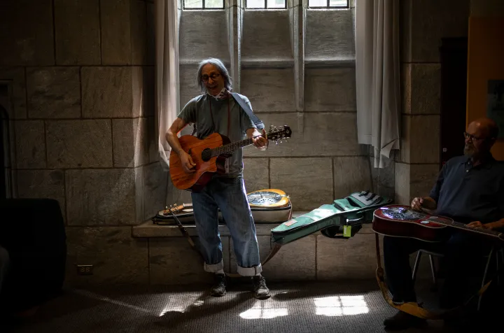 Person plays guitar indoors