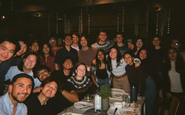 Group of students huddled around table in restaurant