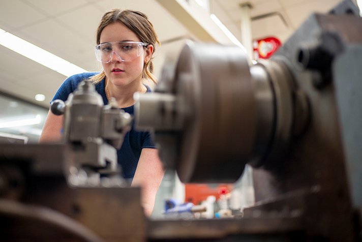 Elizabeth Dentzer wearing goggles while working in machine shop