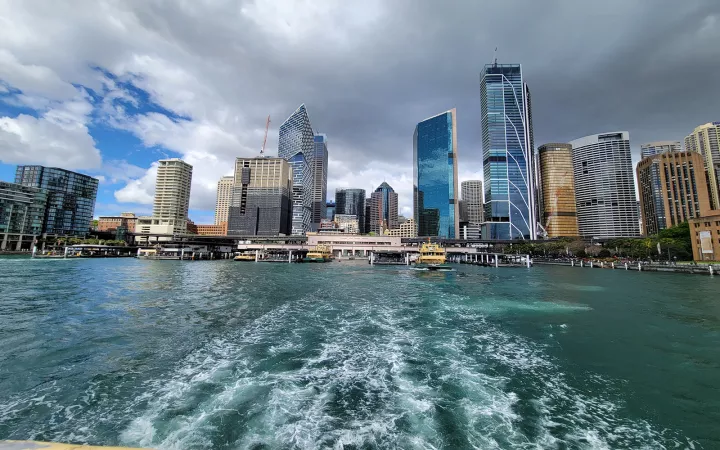 Ocean with frothy waves leading to modern-looking cityscape