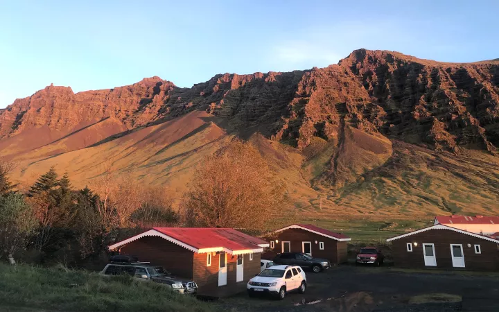 Rocky, reddish-brown mountains with wood houses at base