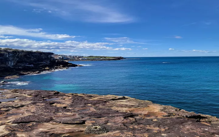 Rocky beach in front of calm, blue ocean