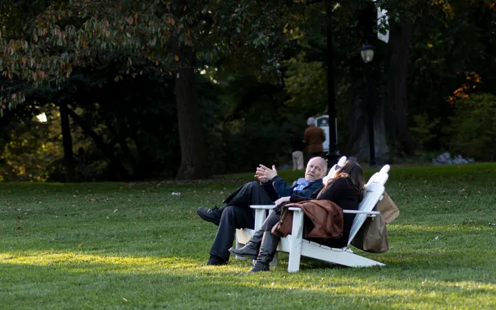 Two people sit on chairs outdoors