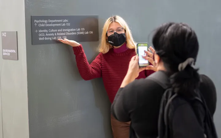 Person poses with sign indoors