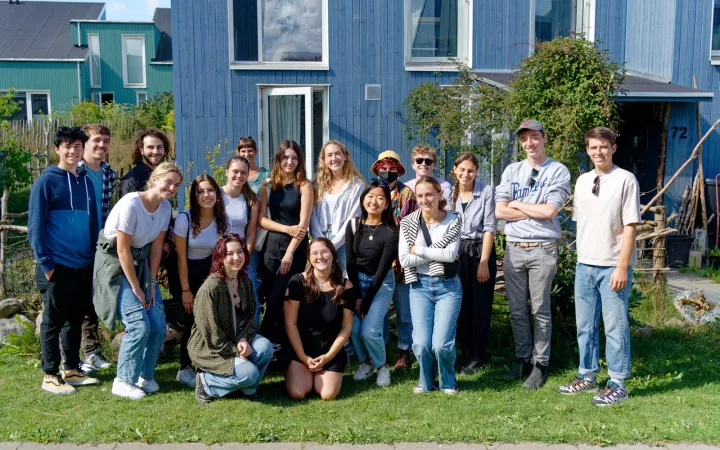 Group of students smiling in front of blue building