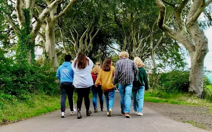 Students walking down forest path, facing away from camera