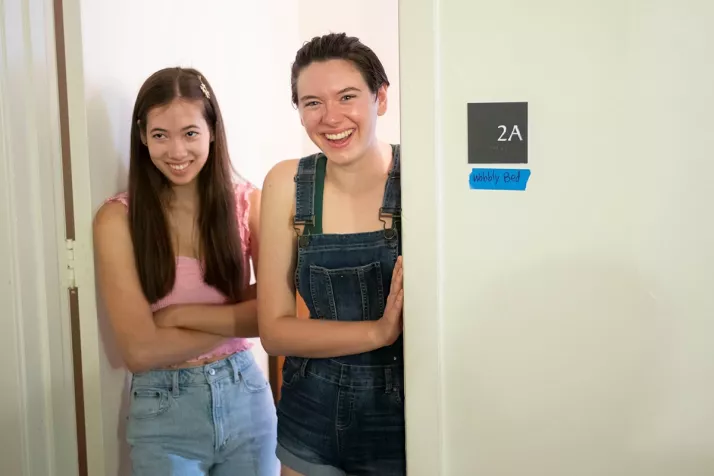 Two people stand in dorm room number 2A