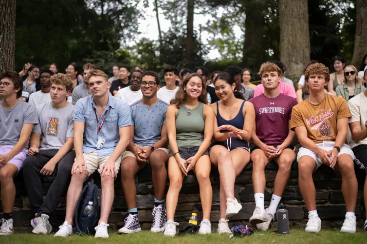 Rows of students sit in outdoor amphitheater in cloudy day