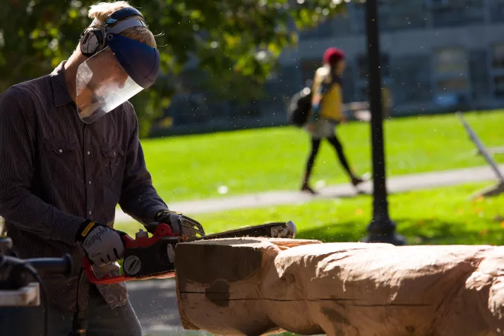 Sculpture student working on senior year sculpture outdoors.