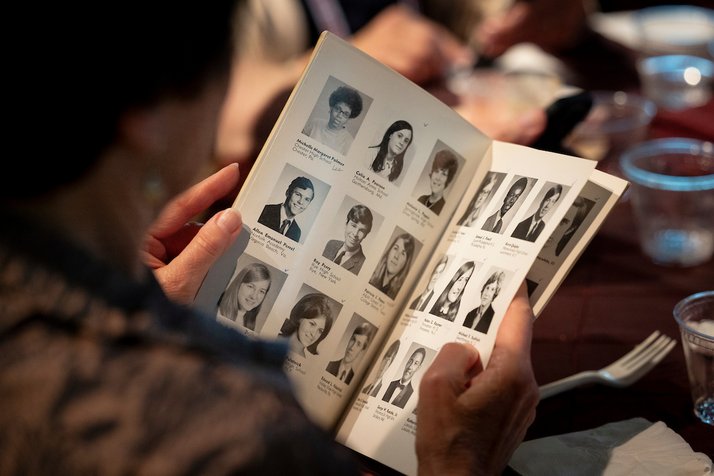 Person looks through class photos in old yearbook