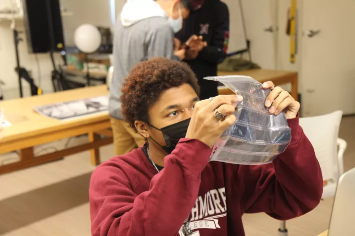 Photo student examining 35mm film strips, Fall 2021