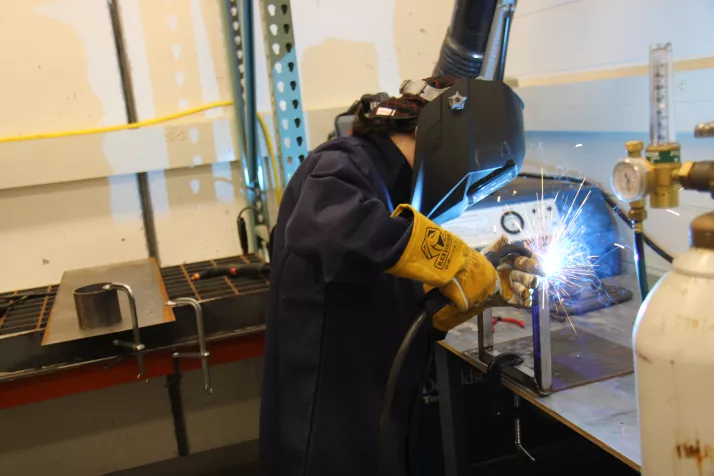 Student welding in the Sculpture II: Metal class.