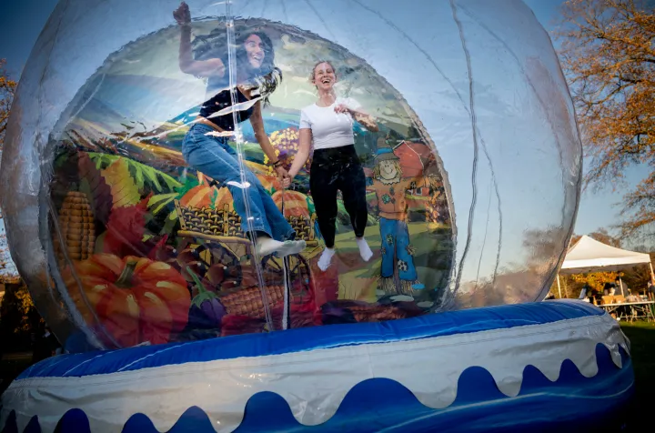 Two people jump around in plastic bubble