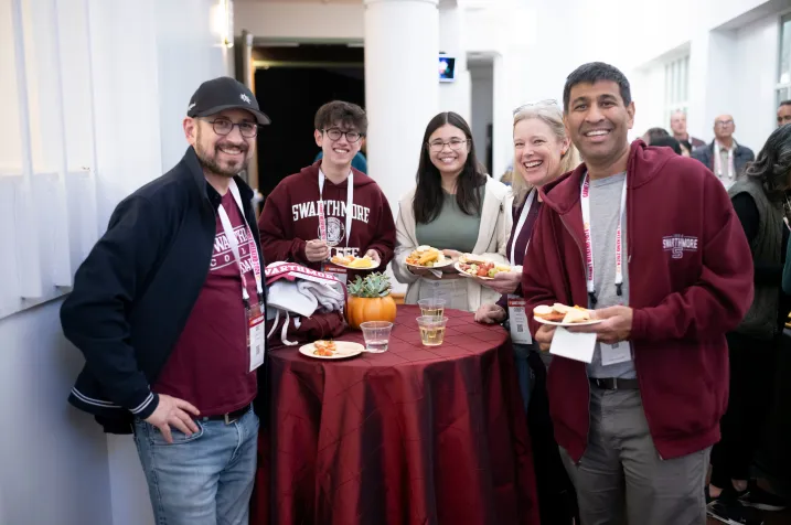 People wearing Swarthmore College apparel eat at table