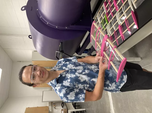 Engineering student holding 3D printed airfoils for testing.