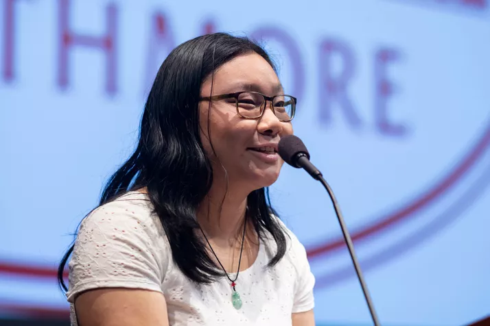 Emmy Li speaks at podium during gathering