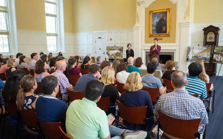 Seated crowd at presentation in Admissions Commons