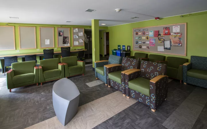 Green chairs inside lounge with gray carpet and green walls