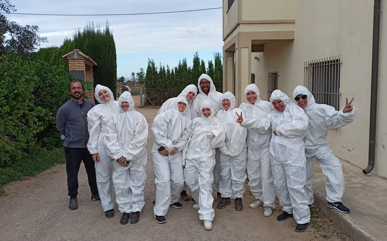 Group of students standing outside wearing matching white full-body gear