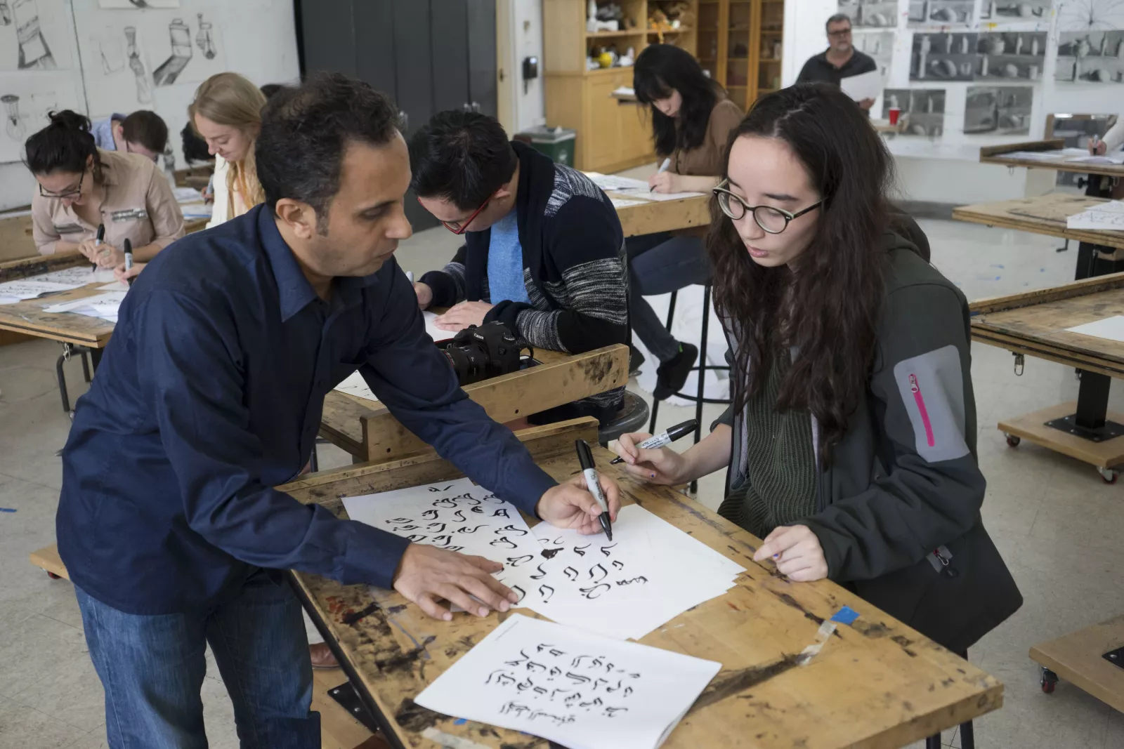 Student receiving aid with her calligraphy stroke