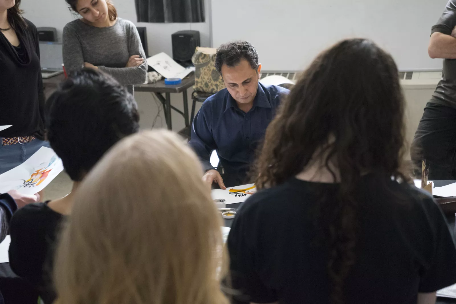 students gather for calligraphy demo