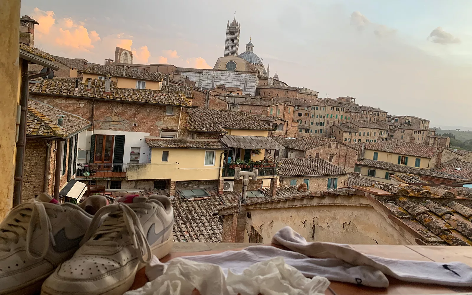 Shoes on rooftop in front of other rooftops receding into distance