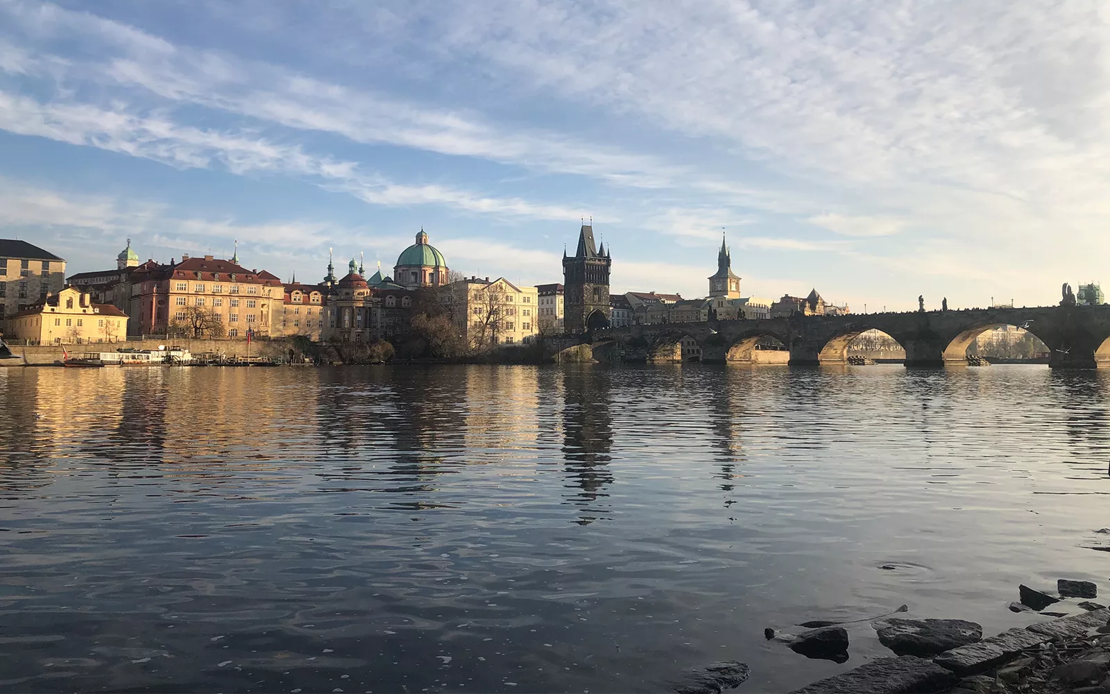 Expanse of water with bridge and buildings in distance