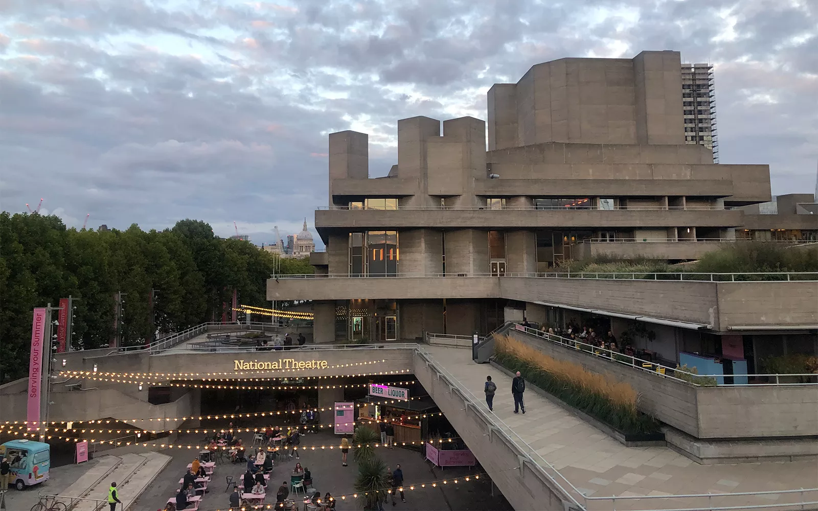 Building with many levels and lit sign that says "National Theatre"