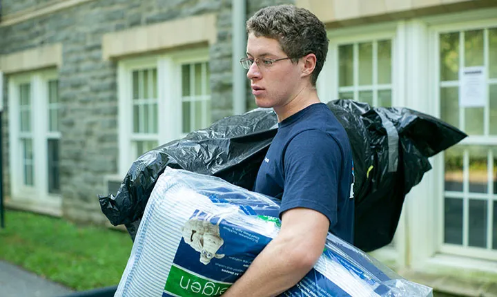 Student with hands full on move-in day