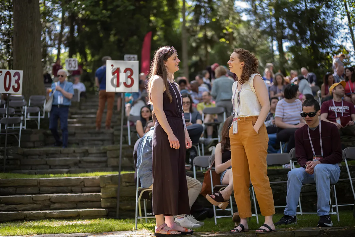 Two people speak to each other in outdoor amphitheater